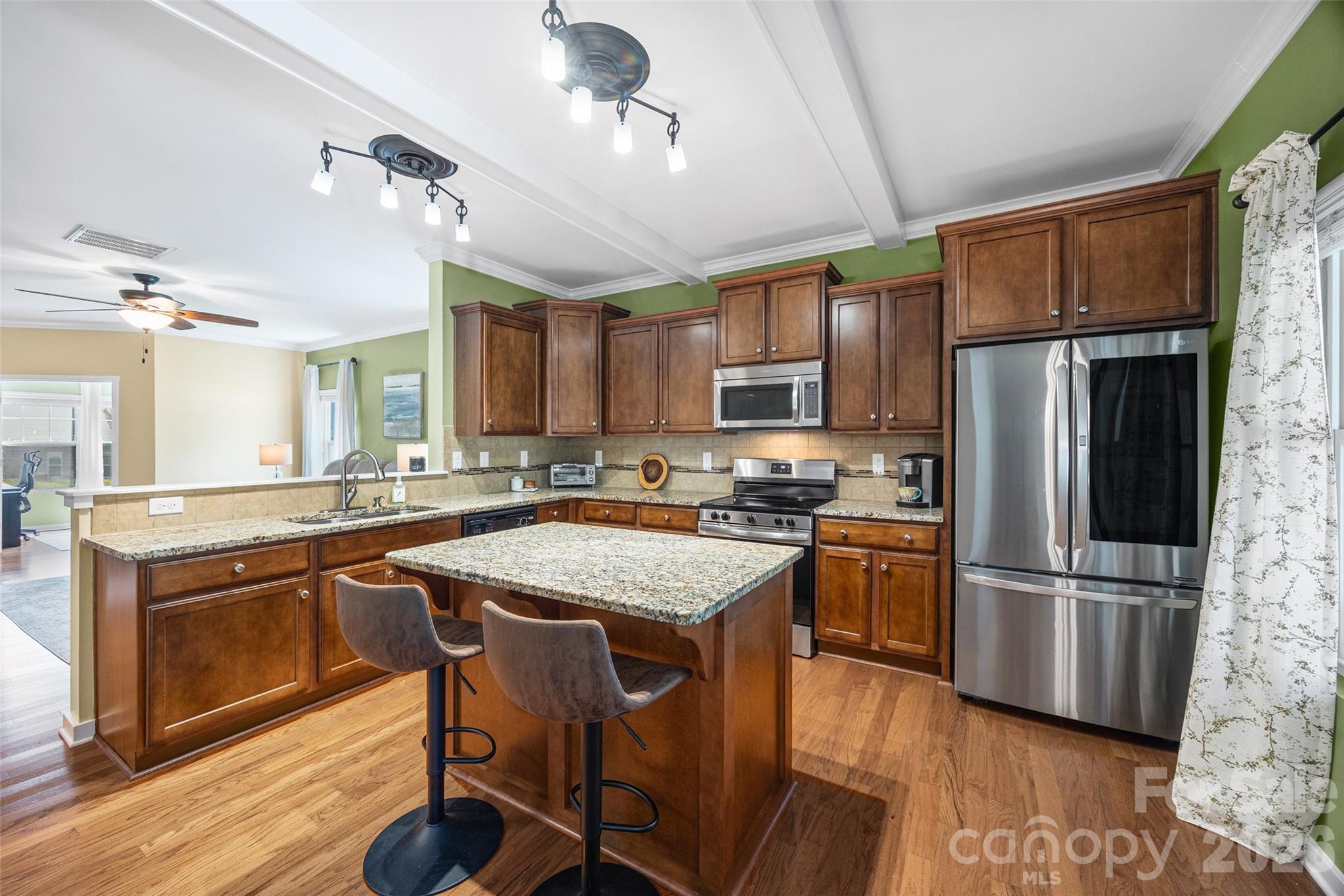 334 Battery Circle Clover, SC 29710 - Photo 9 of 29 a kitchen with stainless steel appliances granite countertop a refrigerator a stove top oven a sink dishwasher and white cabinets with wooden floor