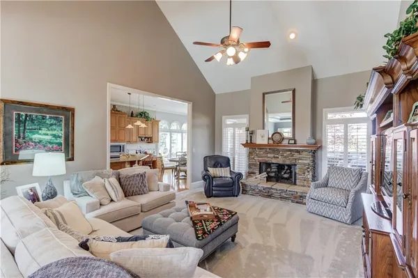 a living room with furniture kitchen view and a chandelier