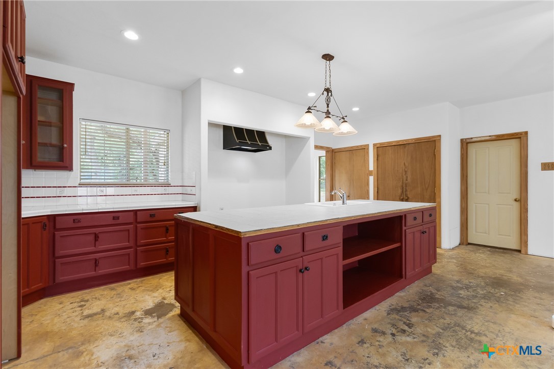 700 Camino De Rancho Wimberley, TX 78676 - Photo 12 of 41 a kitchen with kitchen island granite countertop a sink and a stove