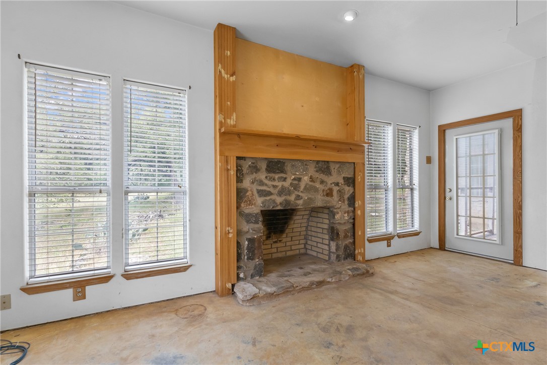 700 Camino De Rancho Wimberley, TX 78676 - Photo 17 of 41 a view of an empty room with a fireplace and a window