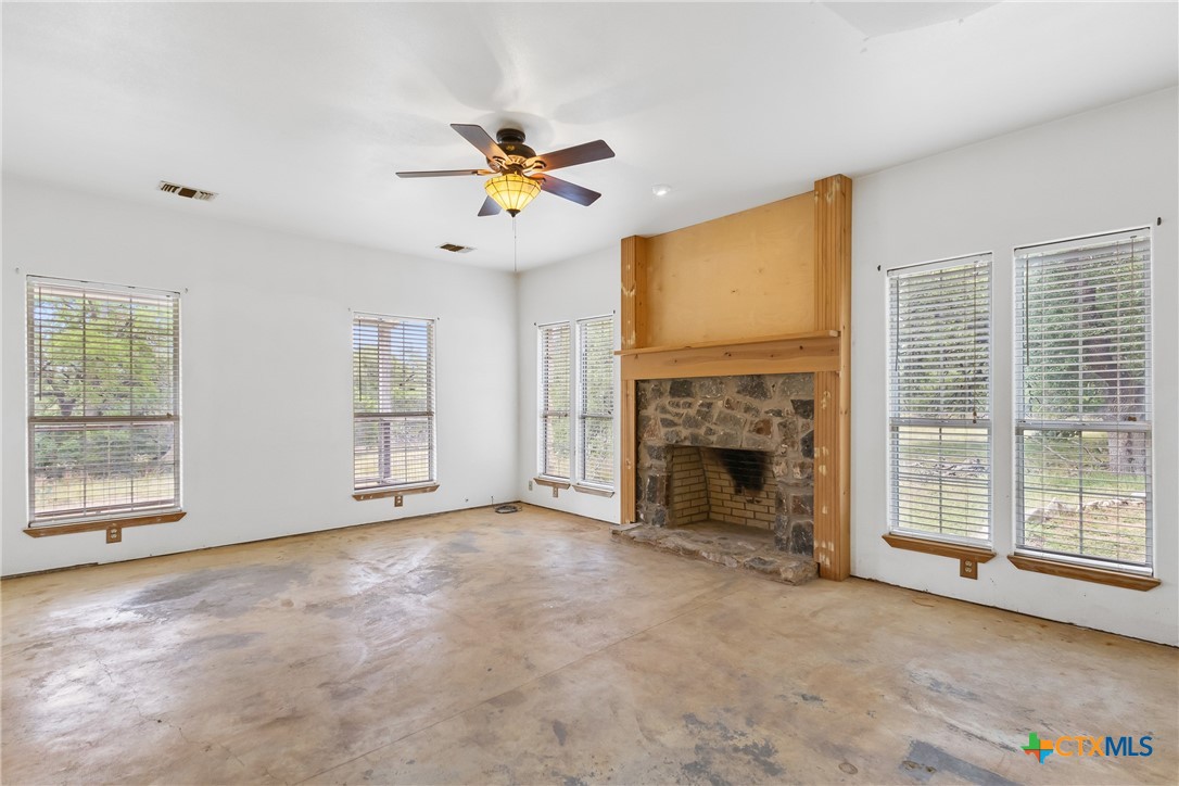 700 Camino De Rancho Wimberley, TX 78676 - Photo 18 of 41 a view of an empty room with a fireplace and a window