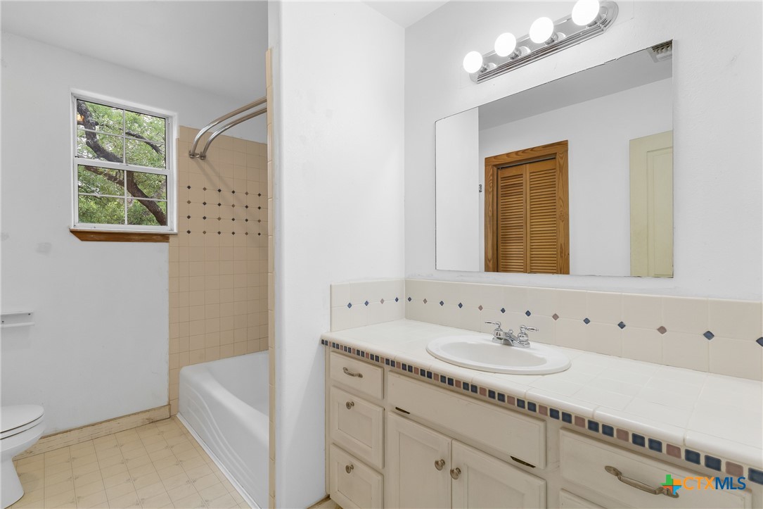 700 Camino De Rancho Wimberley, TX 78676 - Photo 26 of 41 a bathroom with a sink a vanity and a mirror