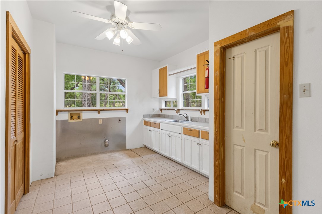 700 Camino De Rancho Wimberley, TX 78676 - Photo 30 of 41 a large white kitchen with a sink and dishwasher with a large window