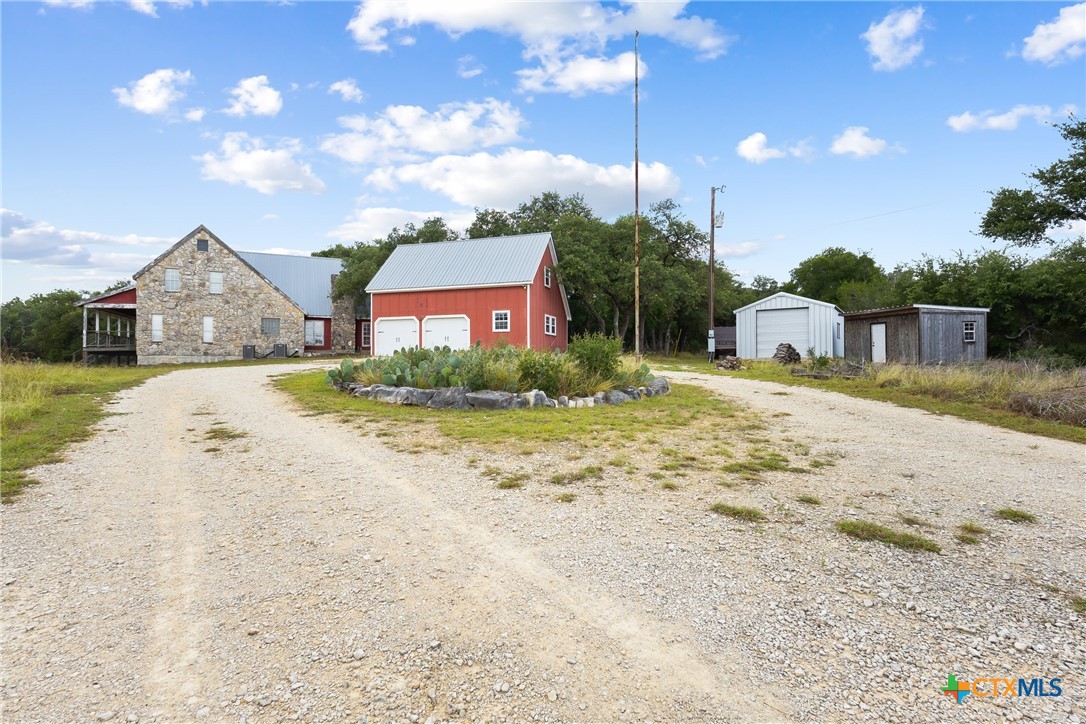 700 Camino De Rancho Wimberley, TX 78676 - Photo 3 of 41 a front view of a house with a yard and trees
