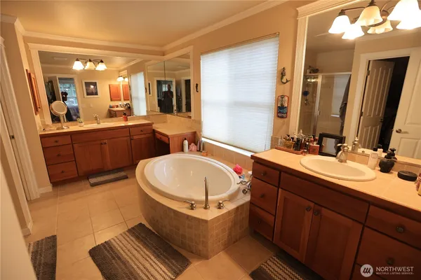 a bathroom with a double vanity sink mirror and bathtub