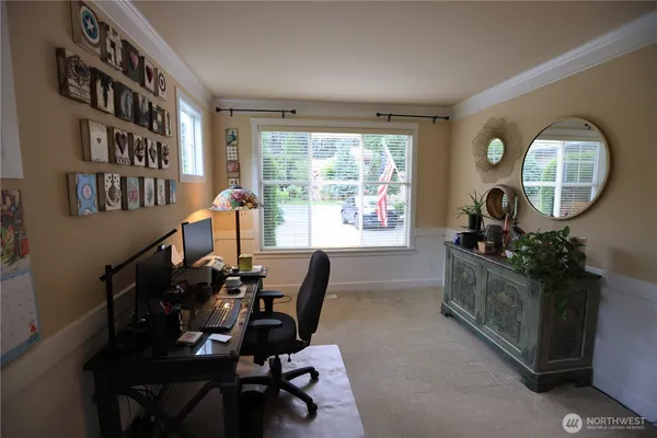 a view of a workspace with furniture and a window