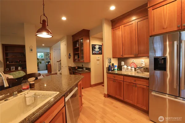 a kitchen with stainless steel appliances granite countertop a sink a stove and a refrigerator