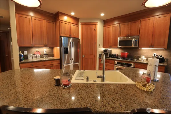 a kitchen with stainless steel appliances granite countertop a sink refrigerator and microwave