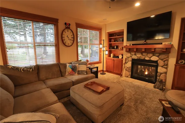 a living room with furniture a flat screen tv and a fireplace