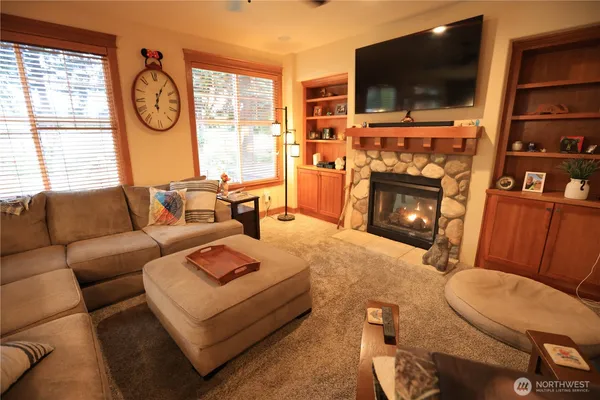a living room with furniture a flat screen tv and a fireplace
