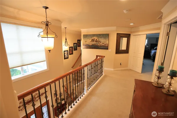 a view of a hallway with wooden floor and windows