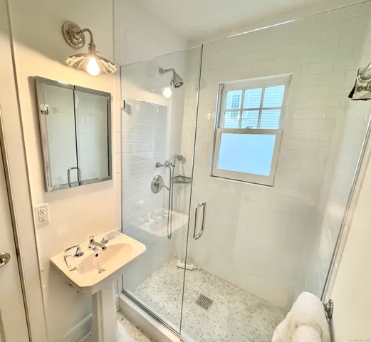a bathroom with a sink mirror and a shower