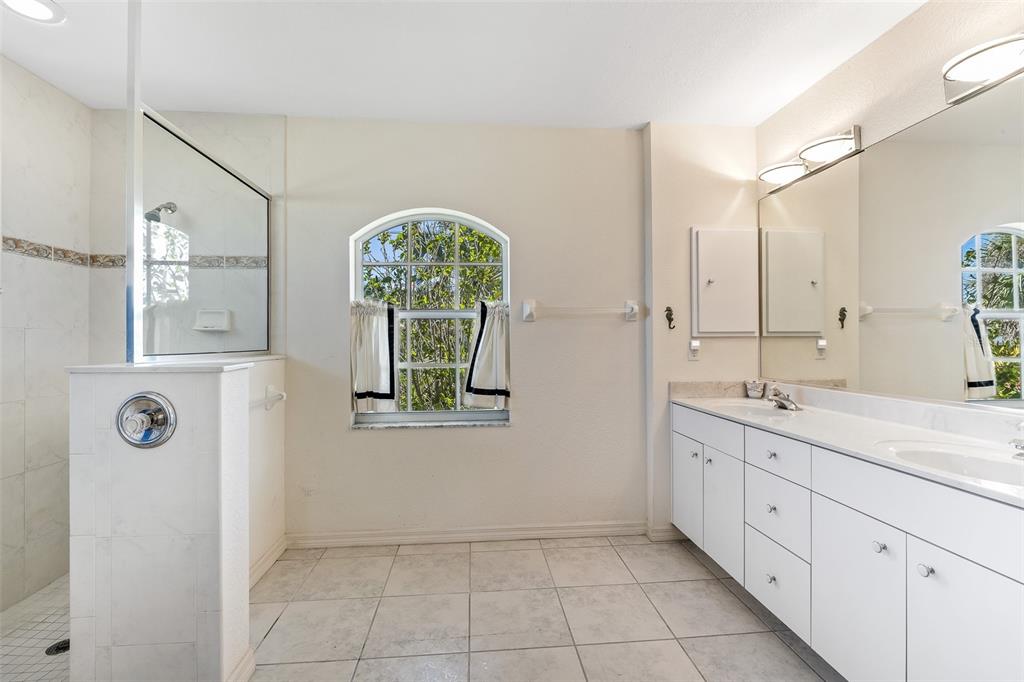 57 Marker Road Rotonda West, FL 33947 - Photo 13 of 27 a spacious bathroom with a double vanity sink and mirror with window