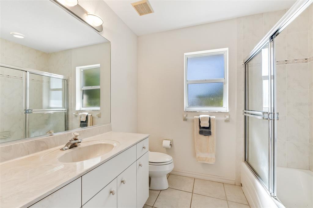 57 Marker Road Rotonda West, FL 33947 - Photo 17 of 27 a bathroom with a granite countertop sink toilet a mirror and shower