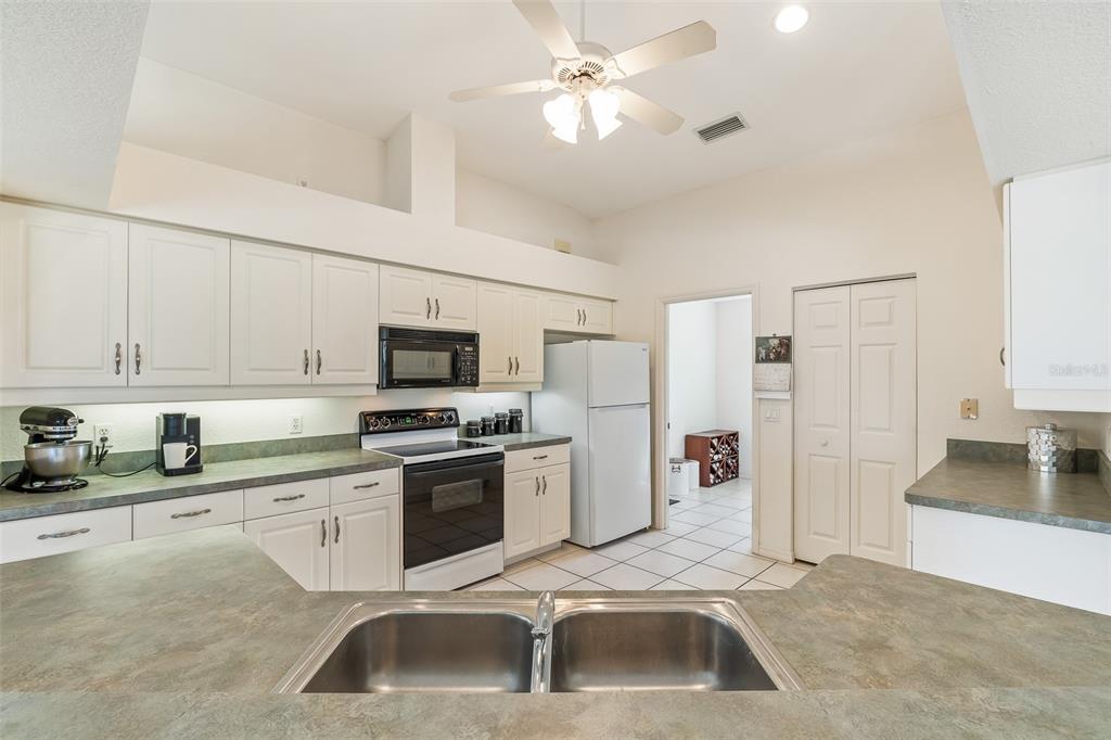 57 Marker Road Rotonda West, FL 33947 - Photo 9 of 27 a kitchen with a sink a stove and refrigerator