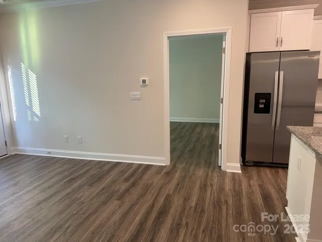 a view of a kitchen with wooden floor and a refrigerator