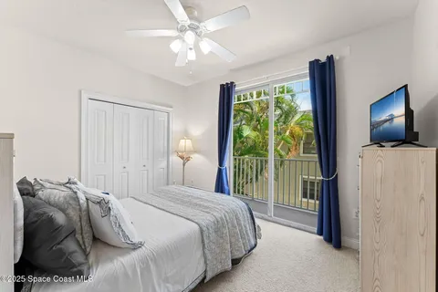 a bedroom with a large bed and a flat tv screen on dresser