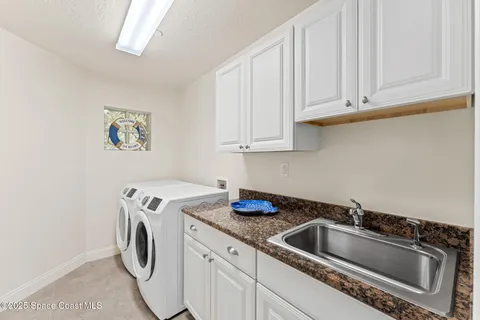 a utility room with sink dryer and washer