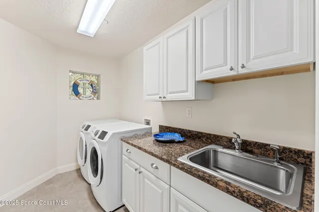 a utility room with sink dryer and washer