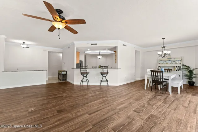 a view of a dining room and livingroom with furniture wooden floor a rug a fireplace