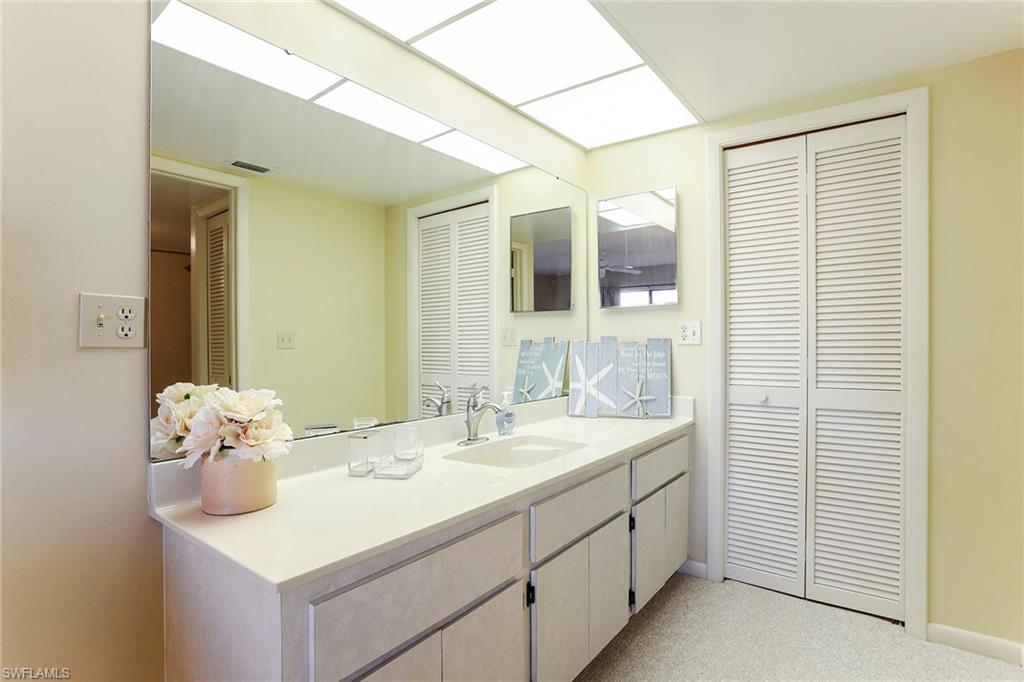 95 St Andrews Boulevard, Unit B209 Naples, FL 34113 - Photo 13 of 18 a bathroom with a sink and a mirror