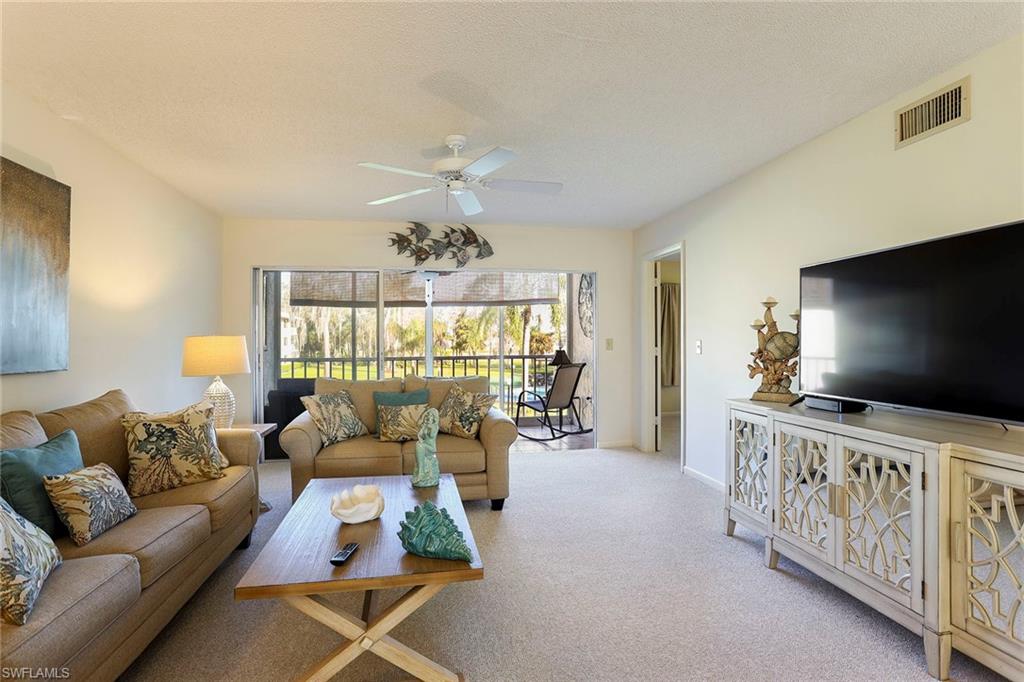 95 St Andrews Boulevard, Unit B209 Naples, FL 34113 - Photo 3 of 18 a living room with furniture and a flat screen tv