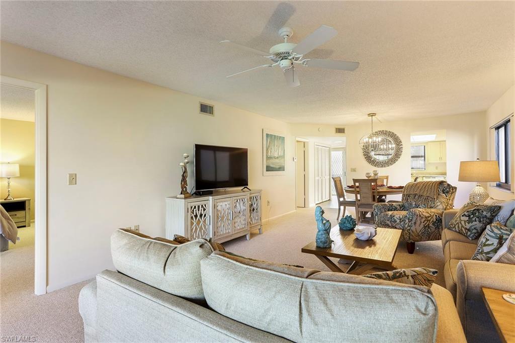 95 St Andrews Boulevard, Unit B209 Naples, FL 34113 - Photo 4 of 18 a living room with furniture and a flat screen tv