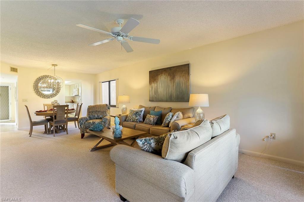 95 St Andrews Boulevard, Unit B209 Naples, FL 34113 - Photo 5 of 18 a living room with furniture and a large window