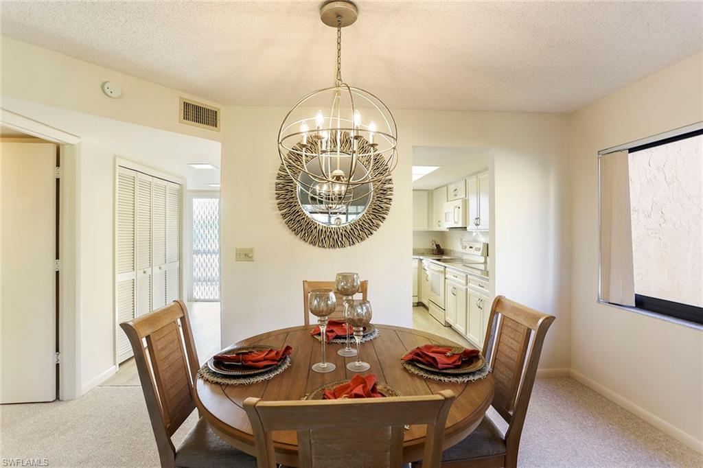 95 St Andrews Boulevard, Unit B209 Naples, FL 34113 - Photo 9 of 18 a view of a dining room with furniture window and outside view