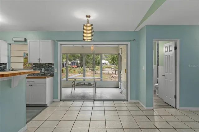 a kitchen with white cabinets and outdoor space