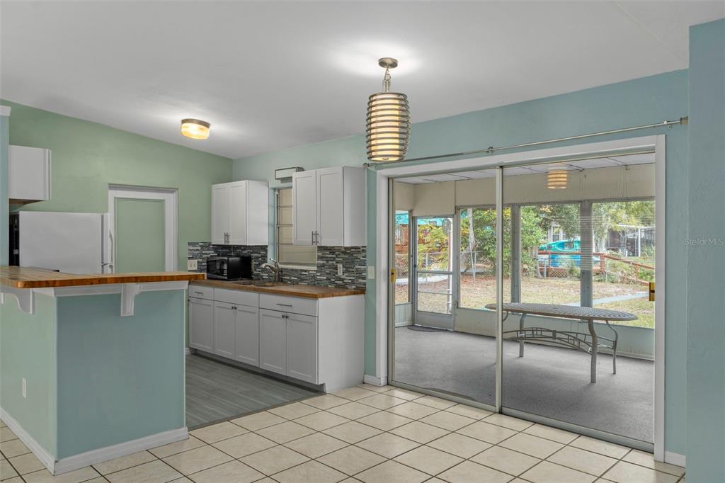 6421 Finance Avenue Weeki Wachee, FL 34607 - Photo 16 of 38 a kitchen with white cabinets and outdoor space