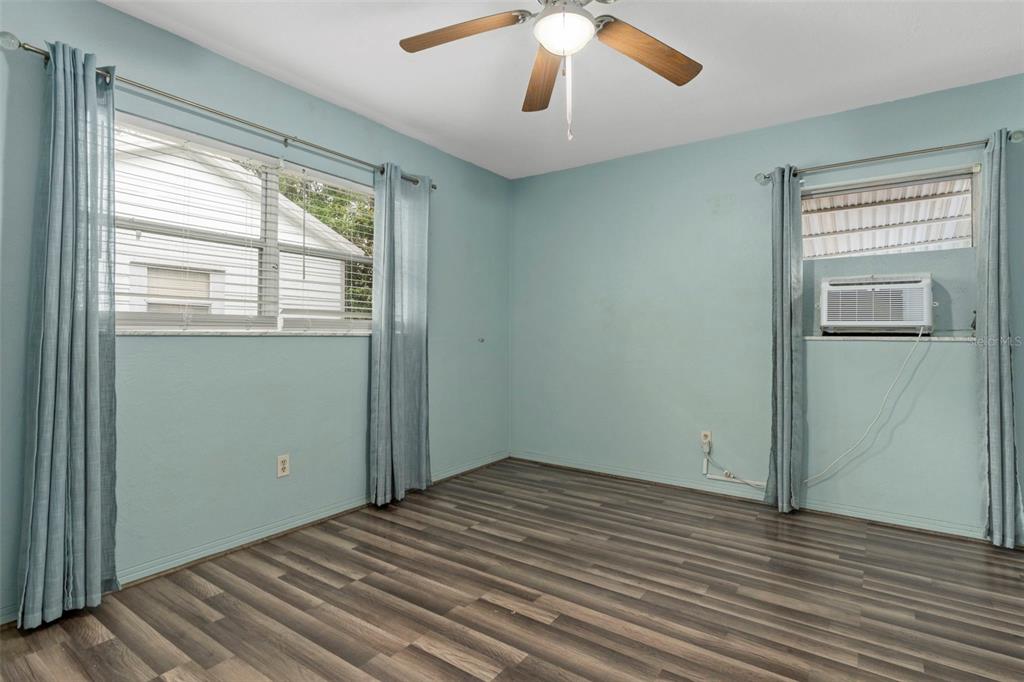 6421 Finance Avenue Weeki Wachee, FL 34607 - Photo 22 of 38 an empty room with wooden floor cabinet and windows