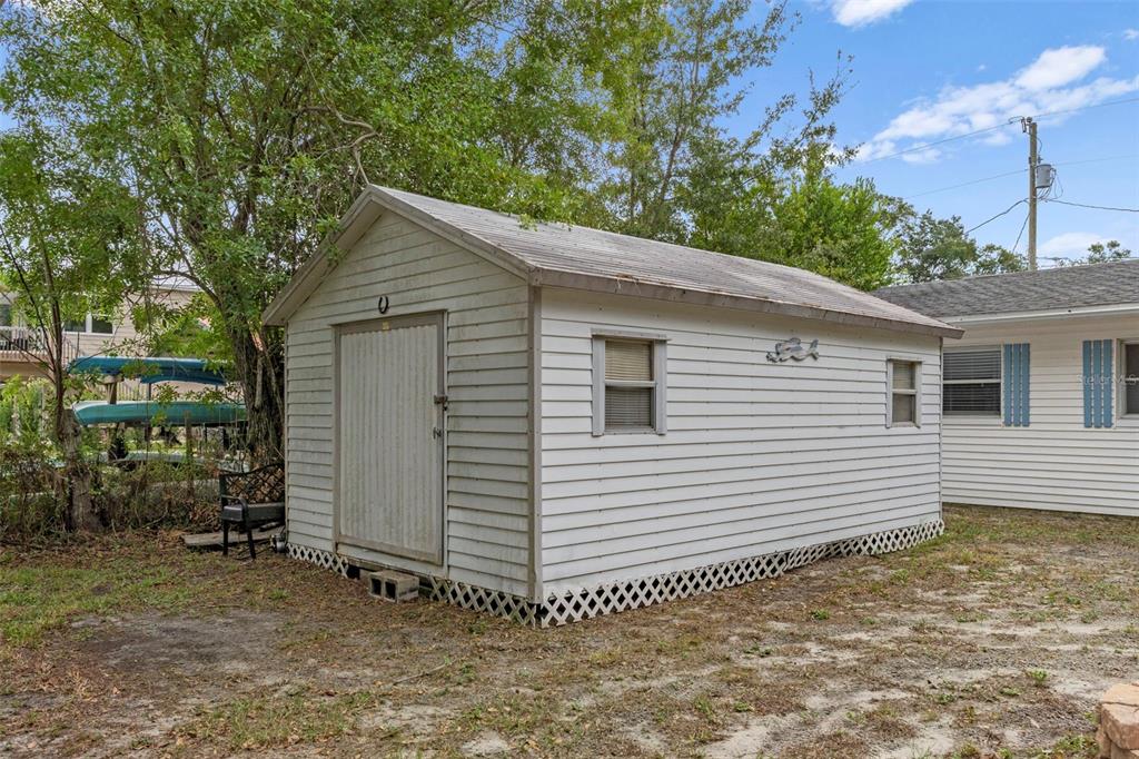 6421 Finance Avenue Weeki Wachee, FL 34607 - Photo 36 of 38 a small white house with a white fence and large trees