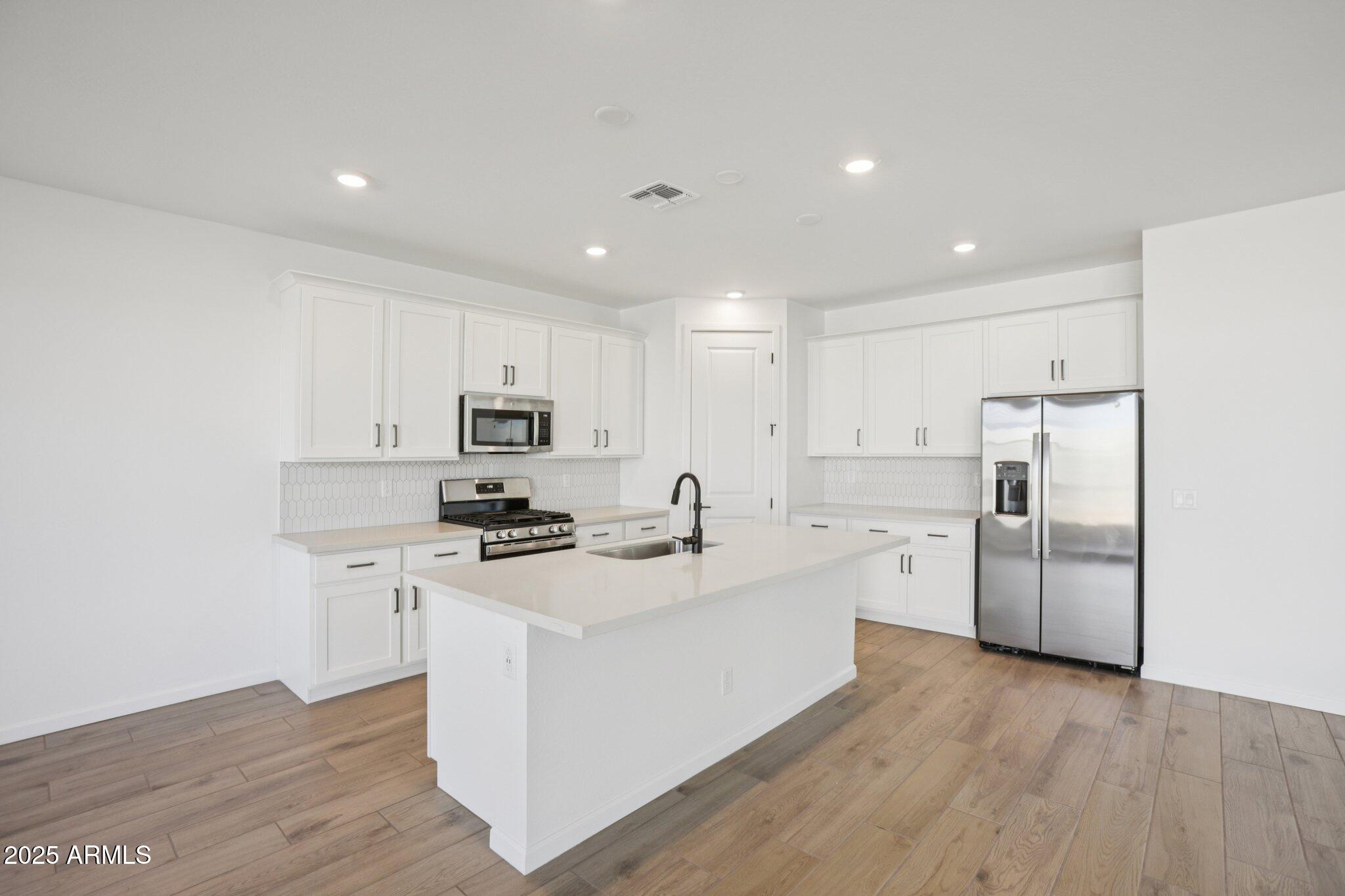 16226 West Bajada Road Surprise, AZ 85387 - Photo 11 of 45 a kitchen with refrigerator a sink and a stove