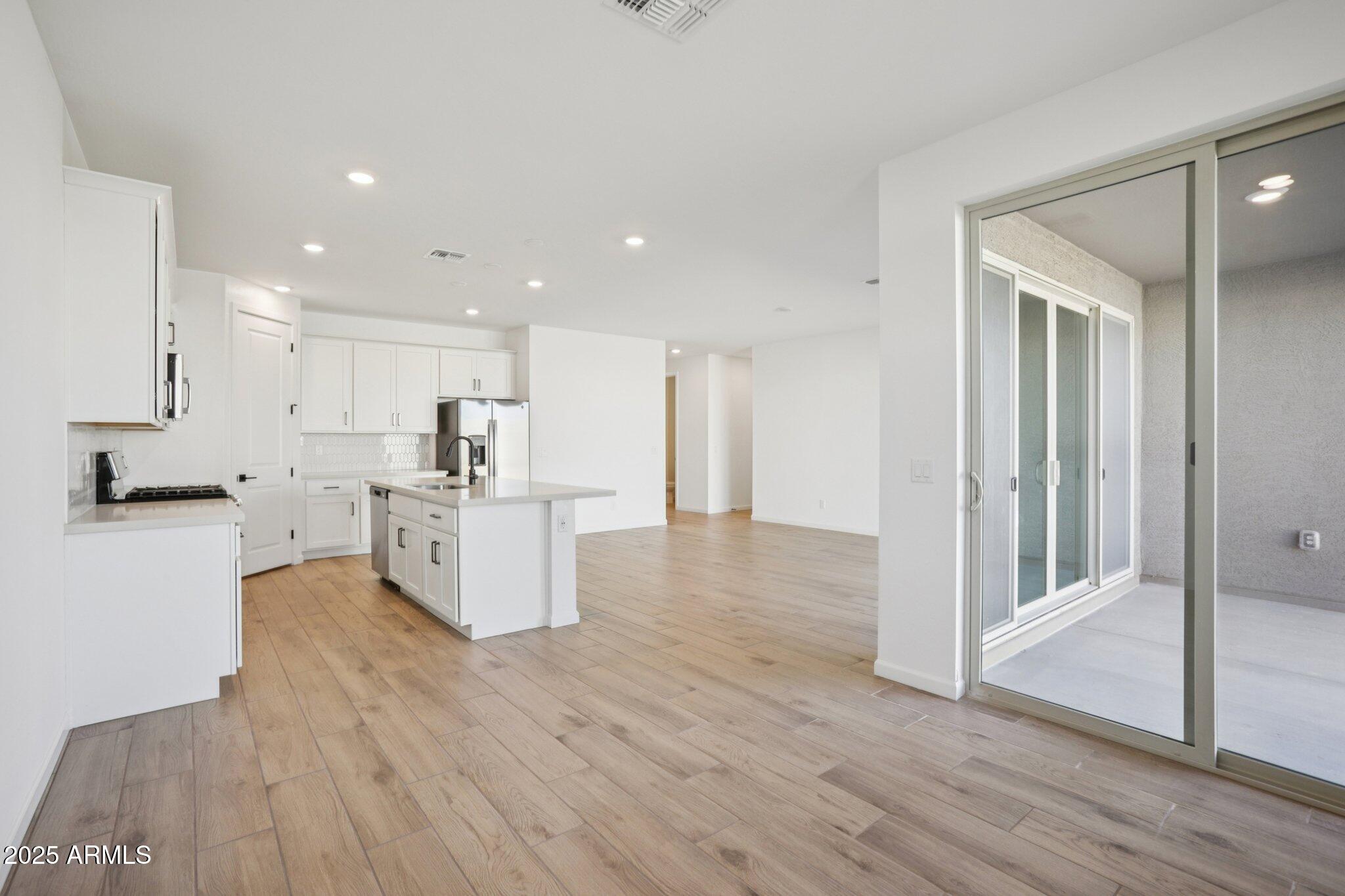 16226 West Bajada Road Surprise, AZ 85387 - Photo 10 of 45 a large white kitchen with wooden floor and a sink