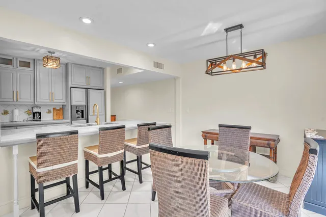 a kitchen with a dining table chairs and white cabinets