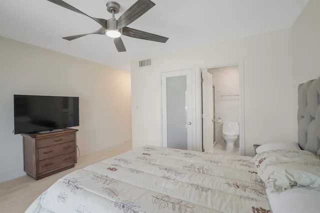 a bedroom with a bed and a ceiling fan
