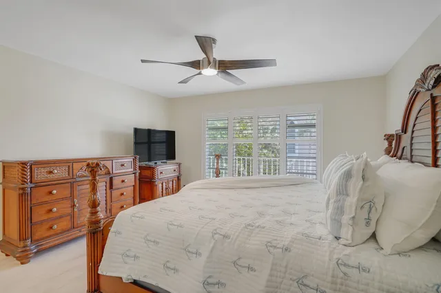 a bed room with a bed and a ceiling fan