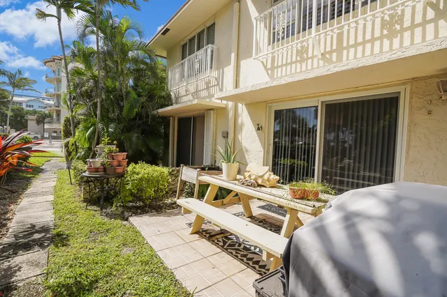 a view of a patio with couches table and chairs and potted plants
