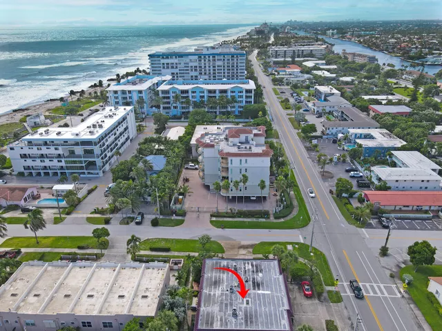 an aerial view of a city with lots of residential buildings ocean and mountain view in back