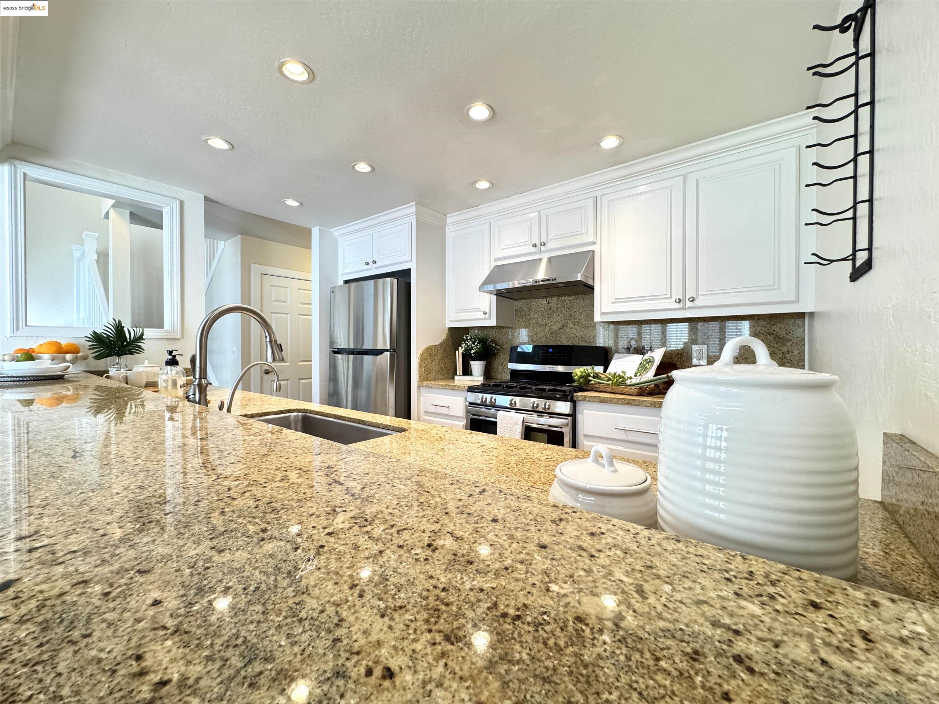3365 Los Prados Street San Mateo, CA 94403 - Photo 12 of 47 a kitchen with granite countertop a stove a sink and a white cabinets