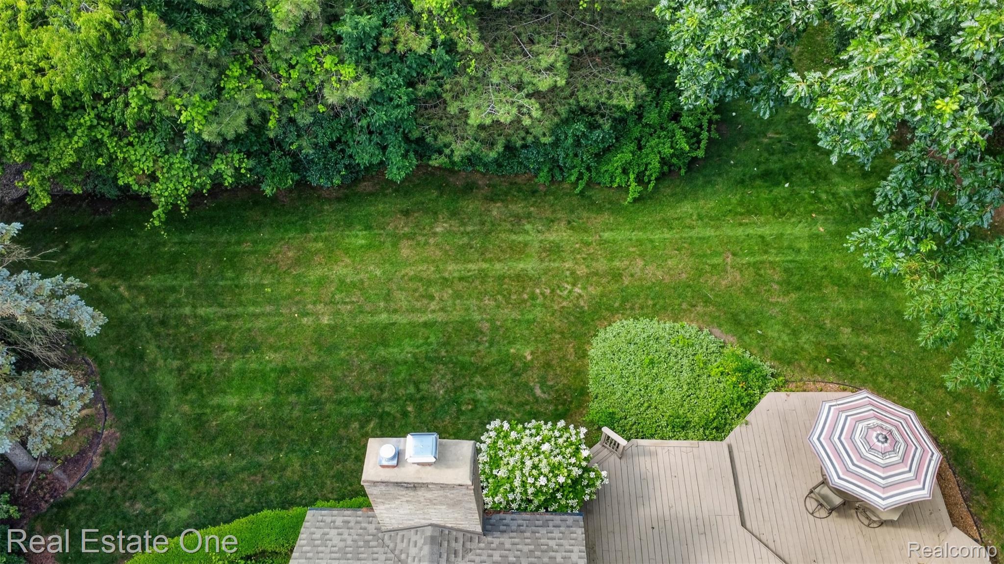 3400 Wedgewood Drive Rochester, MI 48306 - Photo 36 of 49 Expansive rear yard featuring a manicured lawn, established landscaping, and mature perimeter trees