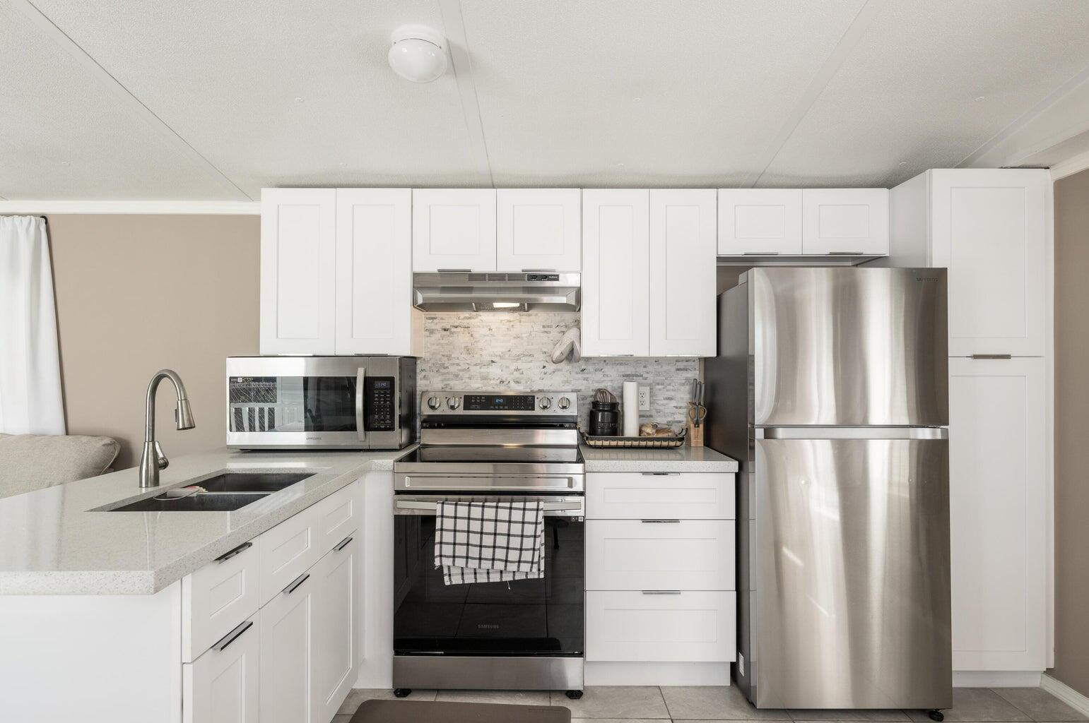 27942 Snapper Lane Summerland Key, FL 33042 - Photo 12 of 26 a kitchen with stainless steel appliances a refrigerator sink and cabinets