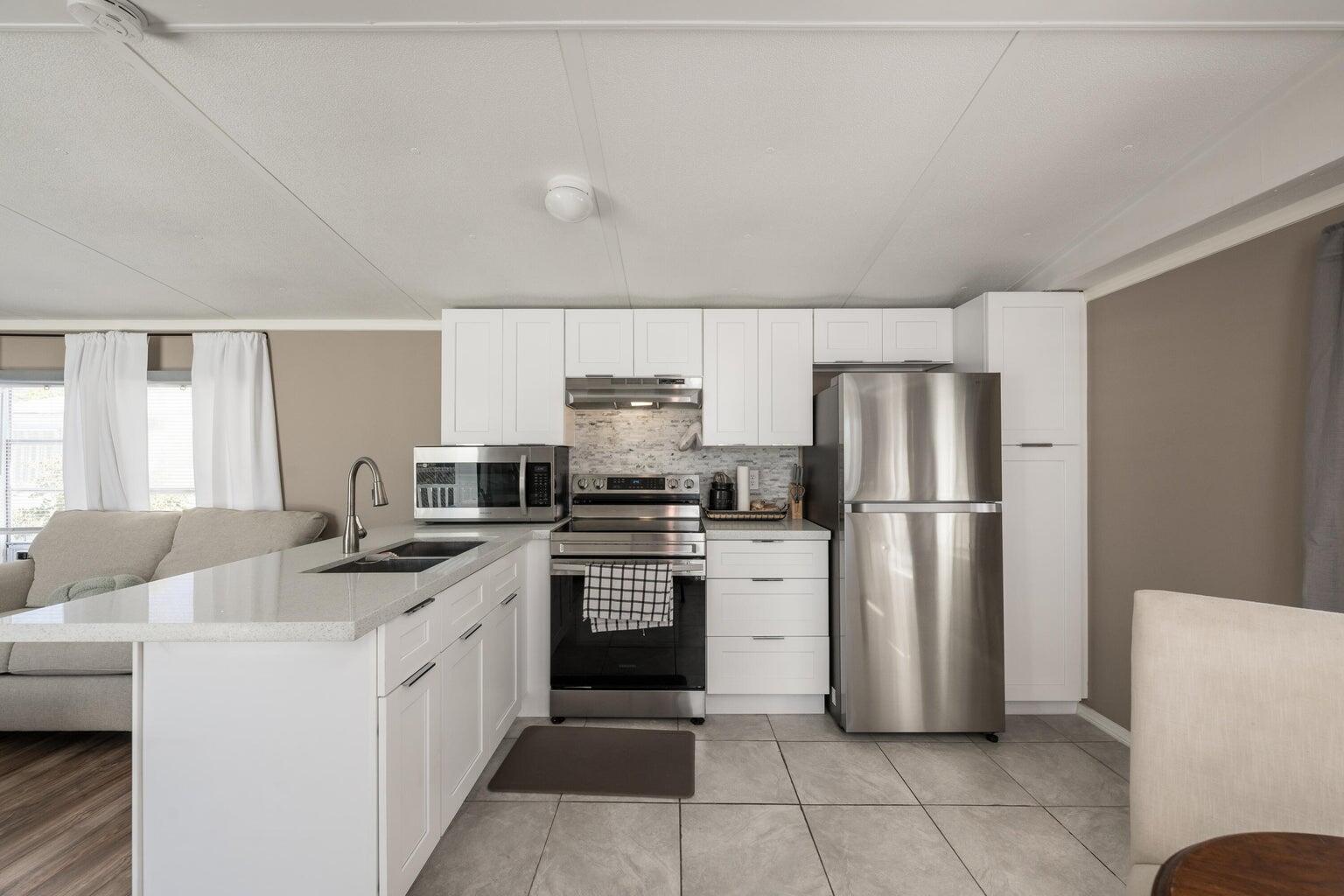 27942 Snapper Lane Summerland Key, FL 33042 - Photo 13 of 26 a kitchen that has a refrigerator and a stove top oven