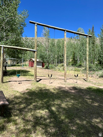 1085 West Elk Road Helper, UT 84526 - Photo 39 of 40 Expansive outdoor area featuring a built-in swing set with multiple swings, a red shed, and a wooden picnic table
