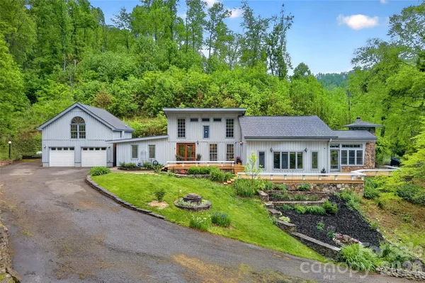 a front view of a house with a yard and trees