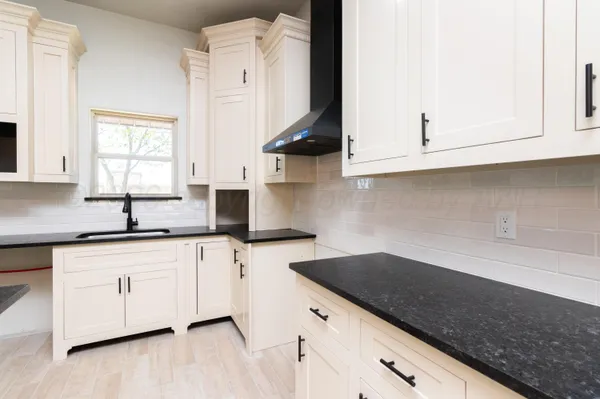 a kitchen with stainless steel appliances granite countertop a sink and a white cabinets