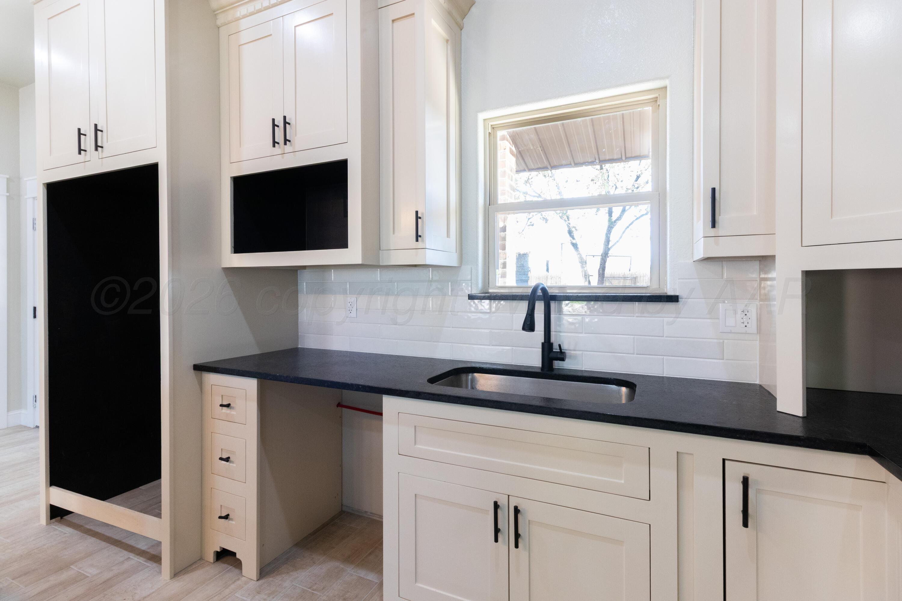 810 South Houston Street Shamrock, TX 79079 - Photo 12 of 42 a kitchen with white cabinets and a sink
