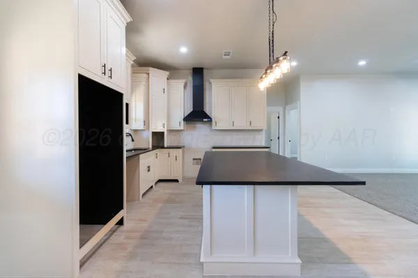 a kitchen with stainless steel appliances kitchen island a refrigerator and a stove top oven