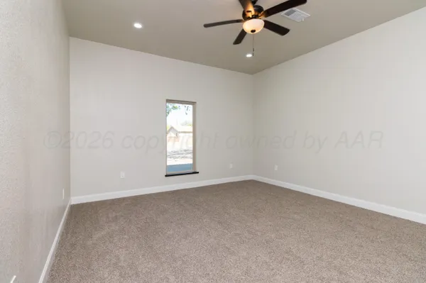 an empty room with a window and a fan